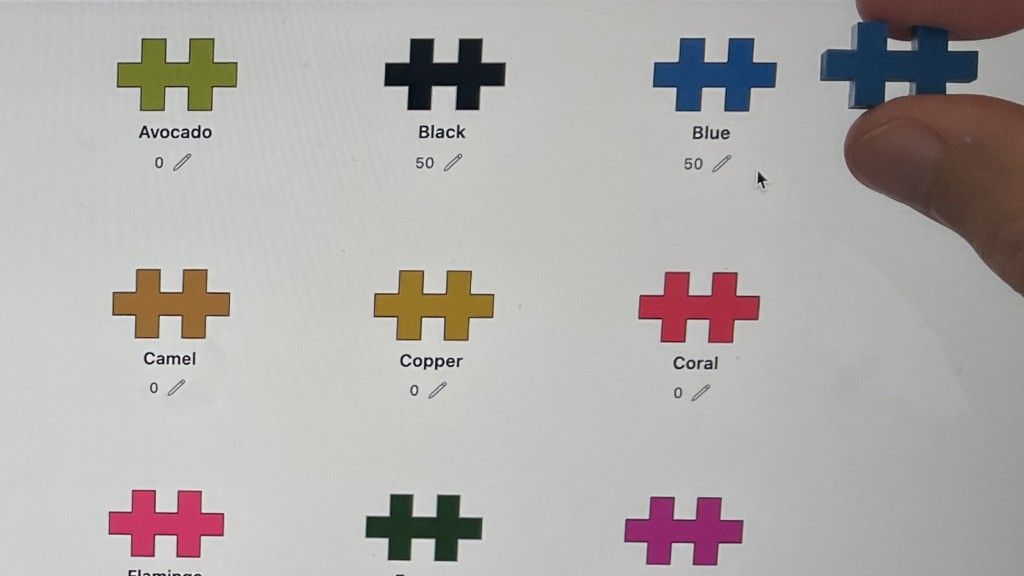 Comparing a physical blue Plus-Plus piece to the matching digital color on screen